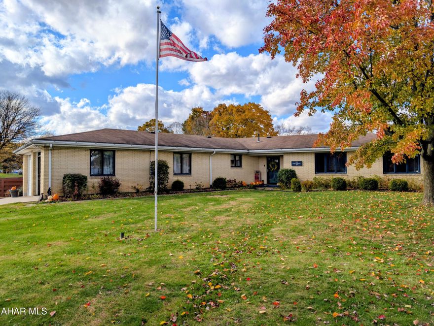 Beautifully maintained, charming, brick ranch boasts of 3 bedroom, 2 bath on 0.629 acres in a peaceful setting with mature landscaping. Welcoming foyer features plank flooring and a Harman pellet stove.
This home offers two spacious living areas: both with a vaulted ceiling and wood beams, one has a large projector setup perfect for those family nights, the other a brick centerpiece featuring a wood stove. Or make this your formal dining room. Both living rooms have electric baseboard heat for an additional choice of heat source.
The study/den/office is filled with natural light from large windows, making it a plant lover's dream. French doors open to a spacious deck, ideal for outdoor dining, entertaining, or relaxing.
Eat-in kitchen includes granite countertops, travertine/marble  backsplash, a Kenmore Elite wall oven, Kitchenaid dishwasher, Kenmore stovetop, and a Broan exhaust fan. Convenient full bath with shower located off the kitchen leading to the attached two-bay garage. Garage features industrial-strength shelving, a pulley storage system, and direct access to a concrete driveway with plenty of parking. Easy access to a small Trex deck and the fenced backyard.
Laundry room is located off the primary bedroom. Additional features include new ceiling fans throughout, custom blinds in four rooms, whole-house central vacuum system, and 200-amp electrical service. The fenced yard area provides privacy and a safe space for pets, with a flat, open lot ideal for outdoor activities.
For peace of mind, the property includes a Ring camera system and eight CCTV security cameras providing full perimeter coverage. A whole-house generator plug is installed—just plug in your generator for power during outages.
Home sits on a concrete slab foundation with utilities ran through the ceiling for easy maintenance. Replaced roof in 2011. Move-in ready with space, comfort, and security on a quiet dead-end street!