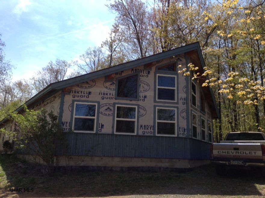 Ready to become your dream home!  This home is 2600 sq ft. plus loft area.  Gorgeous great room with spectacular 4-sided, stone fireplace. Lovely wooded setting.  The home has all plumbing roughed in.  Electric is basically complete - just add fixtures.  Every room has vaulted ceiling with real wood finish.  Well and septic have approved plans but are not completed. Great opportunity in Northern Bedford school district.