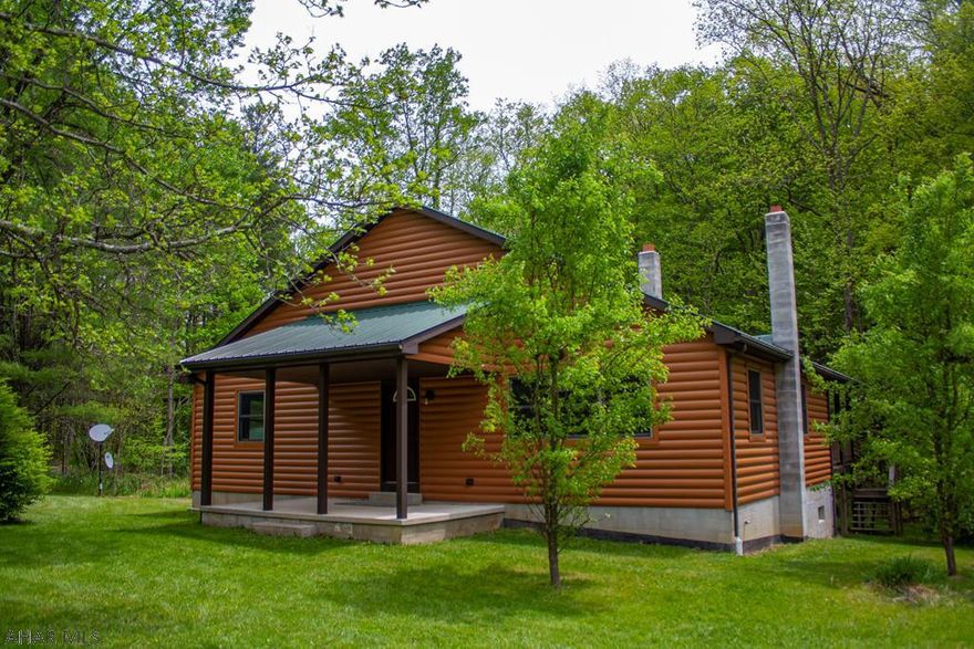 Take a look at this gem!  This well-built beautiful cabin has much to offer you.The 3.29 acre setting is perfect, nestled into the woods complete with a babbling brook wandering through it. Zero maintenance Vinyl log siding covers the outside of this home and an almost new metal roof tops it off. There is a large deck for entertainment on the back of the house and this property backs up against  the state game lands, for even more privacy. There are also 3 outbuildings. Entering  the home, you will not believe the attention to detail. The hardwood floors in the Great Room are alternating Walnut and hickory. There is a propane gas hearth made of El Dorado stone. Many more details and hardwoods used. Treat yourself and make an appointment to see this today! Won't last long! Check the Tour