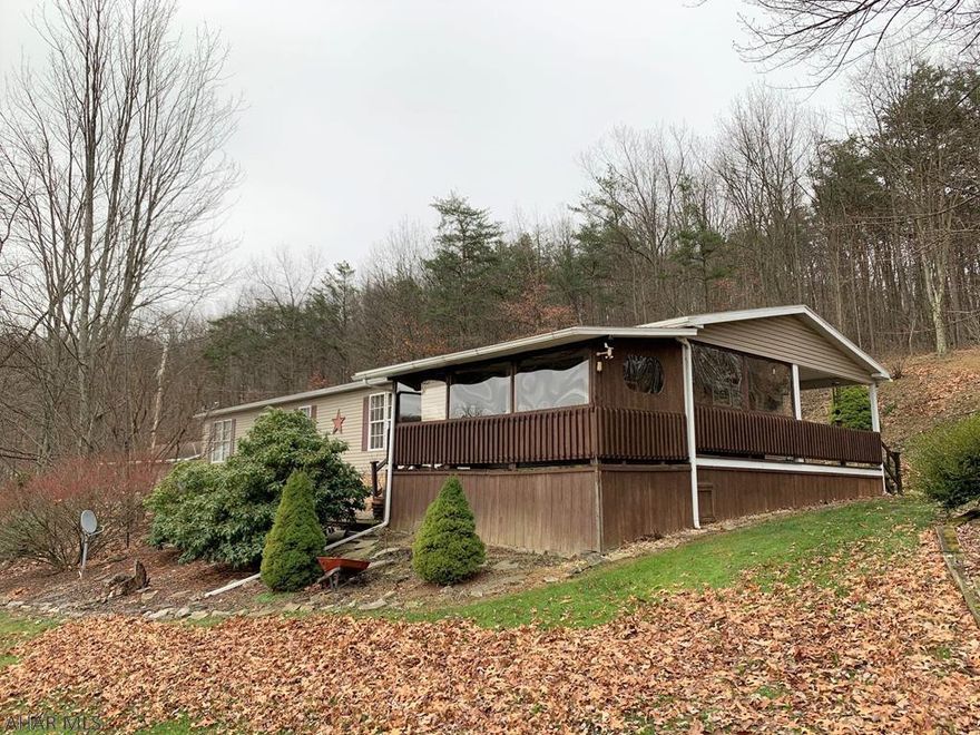 Very well maintained 1-story manufactured home (with stick built additions) resting on 16.64 acres!! This delightful home offers a large living room, dining room, kitchen, office, owner's suite bedroom w/ bath and walk-in closet, two additional bedrooms and a full bath, laundry, and mudroom. Large wrap around enclosed porch with hot tub and rear covered patio. Oversized one car attached garage, detached four-car garage that's insulated and heated, additional detached four-car garage, and storage sheds. Oil forced air heat, wood burning furnace, private well and private septic. Land is mostly wooded with spectacular views of the surrounding countryside! Convenient, central location in the Chestnut Ridge School District!