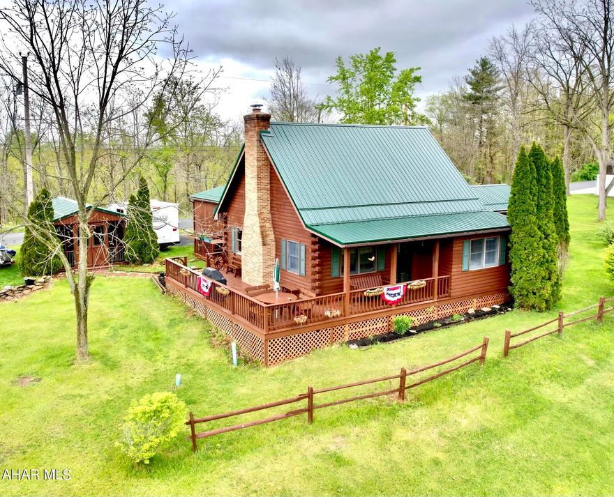 Imagine sitting by a cozy fireplace in your very own log cabin..  If we've sparked your interest you are in luck.   This unique home inspired its present owner to write two wonderful novels while enjoying the sounds of nature and the charm of the Alleghany mountain side.  The home welcomes you with its fabulous loft overlooking the cathedral ceiling living room.  A main floor master suite with huge walk in closet and sitting area adds to the appeal while the separate guest suite  with 1/2 bath provides private quarters for friends.  New heating and air condition metal roof, one car garage, an outdoor building with screened porch are wonderful additions to this quaint log cabin located within easy access to PA turnpike, I99 and the historic town of Bedford.