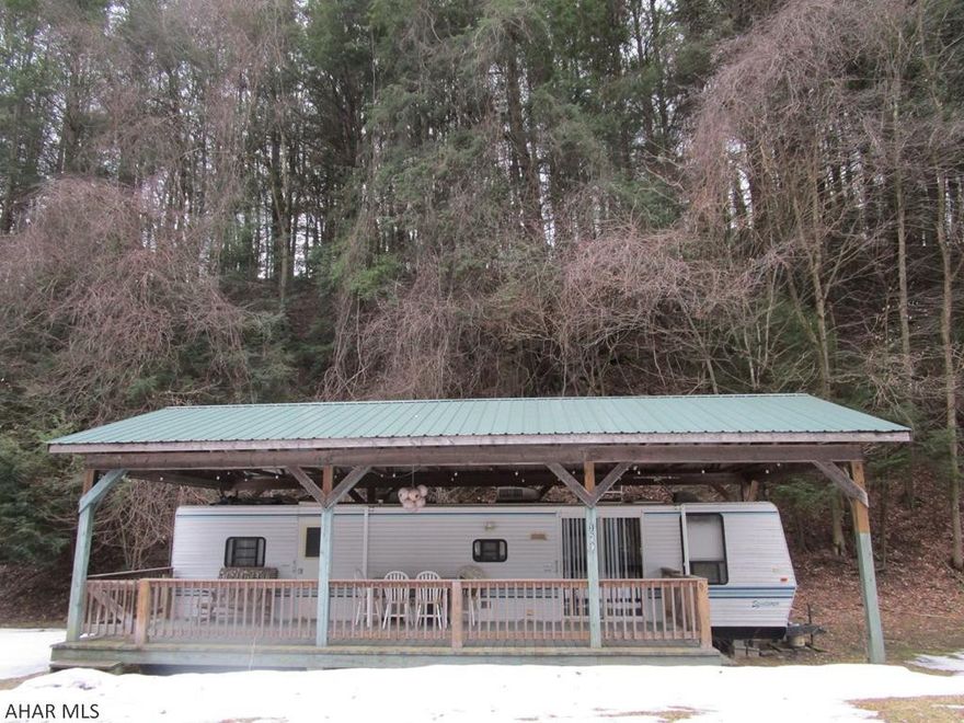 Camping is more fun when you can spend time outside in rain or shine.  This camper and its deck sit under a pavilion allowing twice the usable space.  The camper has two slide outs making the bedroom and living space roomy inside as well.  Sleeper sofa in the living allows comfortable sleeping space for four.  Situated on a quiet dead end road below the swimming pool the location is a plus.  Located in Glendale Yearound, a gated community adjacent to Prince Gallitzin State Park / Glendale Lake and six miles from Rock Run ATV Park.