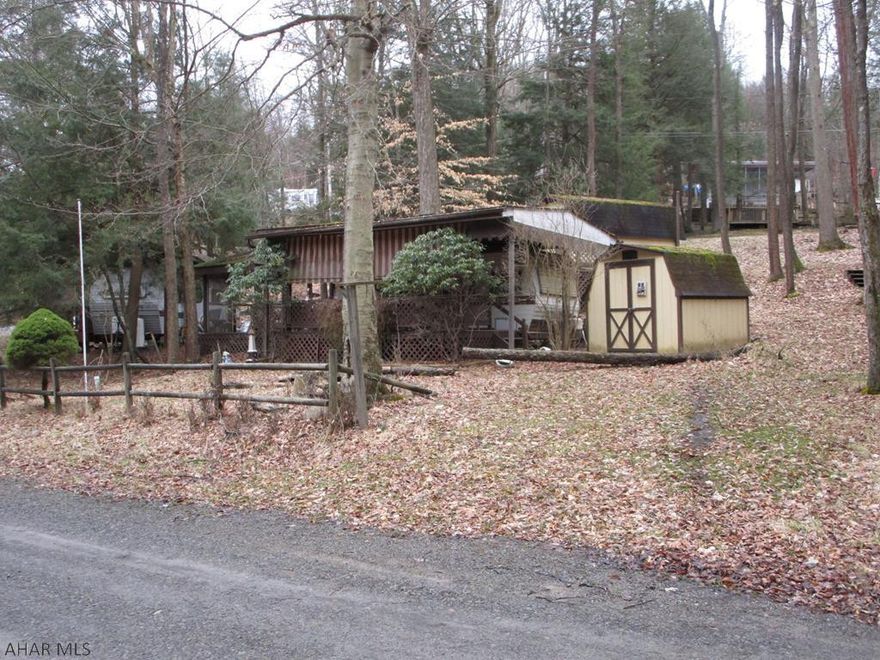 It's camping season and there is plenty of sleeping space on this property.  The camper is older but has two beds along with the kitchen and bath.  Porch is covered.  A separate covered outside area allows you to enjoy the outdoors even if the weather isn't co-operating.  Above the camper sits a bunkhouse with more sleeping space and the second bath with shower.  There is lots of room and potential here.  Just add elbow grease and your imagination.  Located in Glendale Yearound.