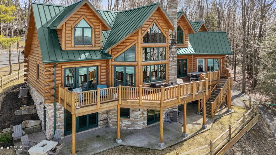 Immediately available and move in ready!!!  Absolutely stunning custom built log home overlooking Indian Lake!!! With remarkable water and mountain views, come experience all this incredible lake front home has to offer! The main level offers a two-story timber frame great room with stone fireplace and a wall of windows; kitchen with granite counters and peninsula bar; a den perfect for music, reading or relaxing; open dining area perfect for guests; primary suite bedroom with walk-in closet, and a custom bath with tile walk-in shower; mud room; half bath; and large laundry room. Open staircase leads to the second level offering three bedrooms; two full bathrooms; and a lovely sitting area. The fully finished walk-out basement has a rec room with wet bar and stone fireplace; living room; bedroom; and an additional bonus room currently used as an exercise area. There are views from every aspect of this quality home. Two-car attached garage and a one-car integral garage offer plenty of storage for vehicles and toys. Hardwood and ceramic tile floors; log and drywall walls; interior and exterior recessed lighting; granite counters and vanity tops; radiant floor and forced air heating system; and central air. Large rear deck with outdoor stone fireplace perfect for entertaining; beautiful boat dock w/ lift and upper deck for gatherings; concrete patio; and covered front porch. This is truly a gorgeous property with expansive lake views! Easy access to major roads, Pittsburgh, MD, and Historic Bedford.