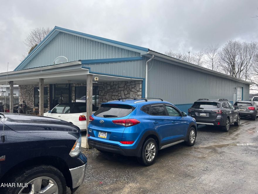 One story stone front pole building on 4/10 acre. Used for an upholstery business the building interior is mostly drywall with concrete floor. There is a kitchenette and small area finished for office or living and a bedroom. Oil radiant heat, alarm system, hdc bath, overhead garage door and front porch. Built in 2006 the building appears in good condition.  Mobile home at rear of property used as a rental or can be removed. Very nice multi use property.