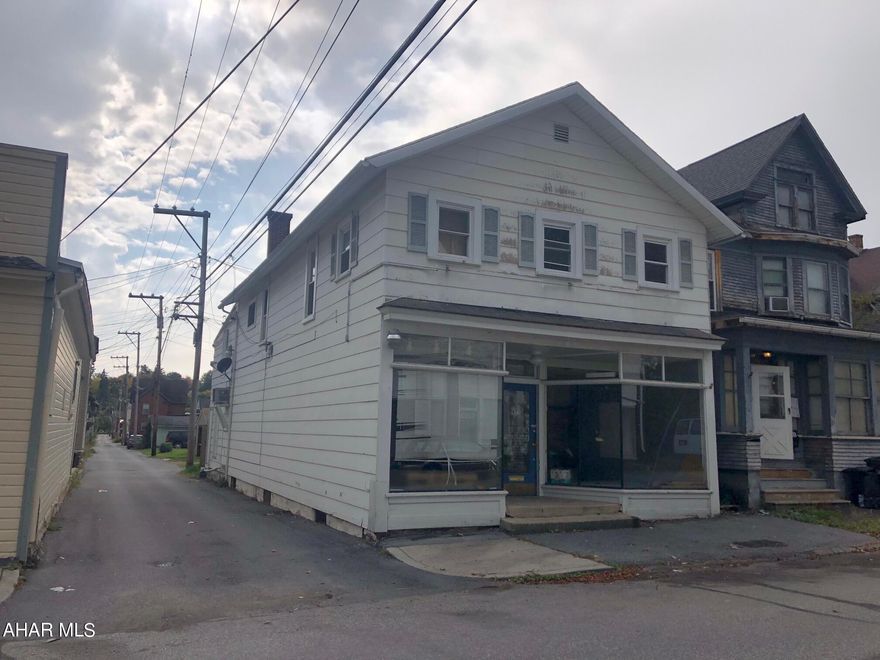 First floor is an open area commercial office with half bath and an unfinished storage room. Second floor is an apartment with a living room, kitchen, and 3 bedrooms with a possible fourth or home office.