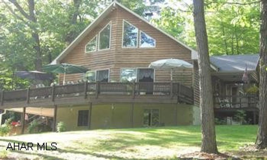 Sinking Valley. Gorgeous & secluded, 3-5 BR, 3 BA, 3 car oversized 2 story garage. Call Jill for more details 330-4309. Approved buyers only! Walk through the front door & be captivated by the floor to ceiling windows w/a southern view & a free standing wood FP, which separates you from the DR. Through here you will find the kitchen w/honey brown cabinets, all appliances, ceramic flooring, & neutral countertops. Continue to the hallway there's a full BA & 2 spacious guest BR's. Going up the stairs you never lose the view of the outdoors, at the top is a generous sized loft looking out over the LR. The hallway to the right holds the MBR w/BA & ample closet space. Leading to the BSMT is a living space worthy of living in, with w/w carpet, wood burning stove, full BA, and a den, which could be used as 4th BR. By the walkout is another room that is nicely maintained as a summer kitchen, laundry, & utility room. Other features to this incredible home is a wraparound deck & a 2 story oversized 3 car garage w/water, electric, cable, & telephone. Surrounded by mature trees, you will have room to play on 2.73 acres w/fenced-in orchard, horseshoe, volley ball, hot tub, & fire pit. Also within walking distance to State Game Lands. Heating & cooling is as simple as choosing what type from C/A, oil, wood, or heat pump. Asking $254,900. You will be impressed! Call Jill 330-4309. Approved buyers only!