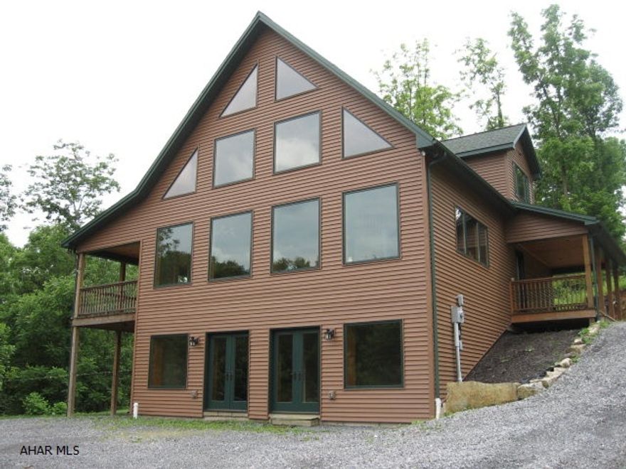 Large contemporary home on private 2.8 acres!  Low maintenance & utilities.  Ground level basement finished w/2 French doors that welcome you into a recreation room w/laminate, 3/4 bath, FR w/carpet & utility room. Whole house has beautiful pine doors w/oak trim, open oak staircases, recessed lighting. Main floor has vaulted T&G knotty pine ceiling open across 2nd floor. Kitchen is hickory cabs w/granite countertop. Great lighting fixtures throughout. DR & LR have full wall of windows to vaulted ceiling. Hickory floors. DR has access to 18x10 front deck. 2 Bedrooms, full bath & laundry room plus 8x20 back deck finish the main level. 2nd level has MB loft, WIC, gorgeous bath w/ceramic tile around Jacuzzi; rounded shower. Vinyl siding w/wood look. Manoblock plumbing system. Heat pump w/AC.