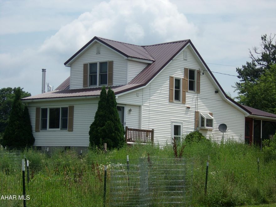 Quiet in the country.  Lovely 2 acre parcel with 2 bedroom Cape Cod.  Property is buffered on 3 sides by fields, with a line of woods in the back for privacy.  Perfect for a mini farm experience - established chicken pen with staggered feed plantings.  Good fishing in Cove Creek across the street from the property.  Home has a screened-porch facing the back yard.  Lot is level with outstanding sunrise / sunset views.
No lack of storage in this kitchen with knotty pine cupboards and separate large dining area.  Spacious living room with space for a wood stove.  Upstairs has two bedrooms and  a small office .