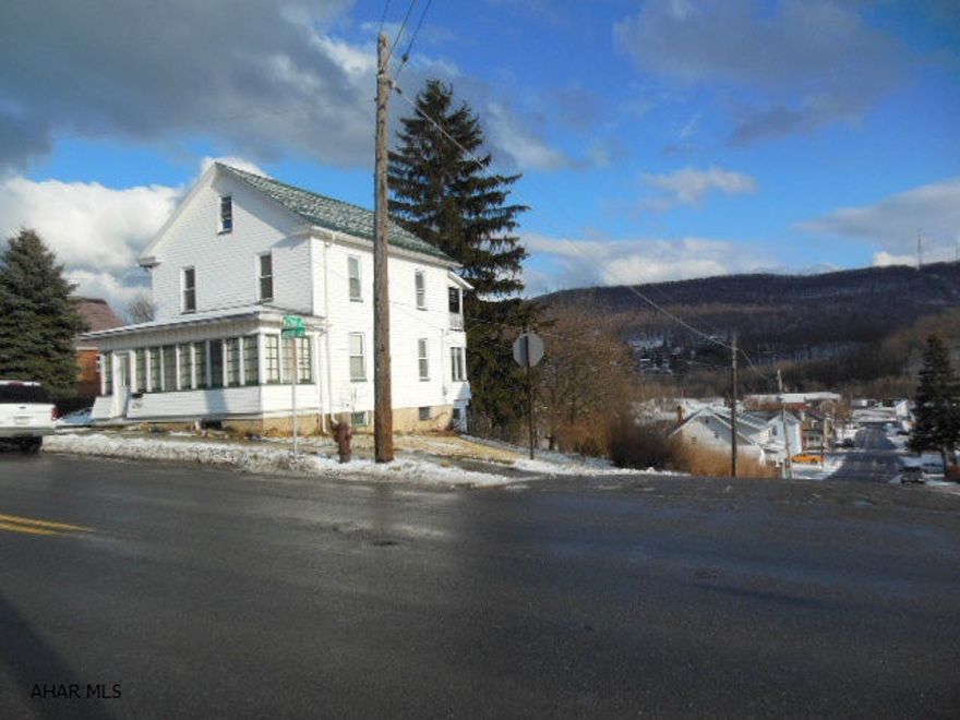 Good 2.5 story on a large corner lot with 3 bedrooms, 1 bath (3/4), LR, DR, kitchen with closed-in front & back porches. Back porch has a beautiful view of Borough & mountains. A one car garage at the base of the lot. Updated siding, roof, windows, electric service, OFA furnace. Large entrance foyer. Attic could be finished. Low taxes & reasonably priced! As-IS condition. Home Warranty!