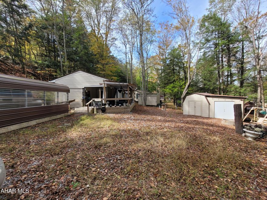 If you are looking for privacy, space for the whole family and all the comforts of home, look no more.
This property is tucked in to a quiet corner.  The unit has an addition along with a large porch area, a pavilion cover for your boat, car or golf cart.  The large shed houses a washer and dryer along with an additional refrigerator.
Utilities are set up for year round living.