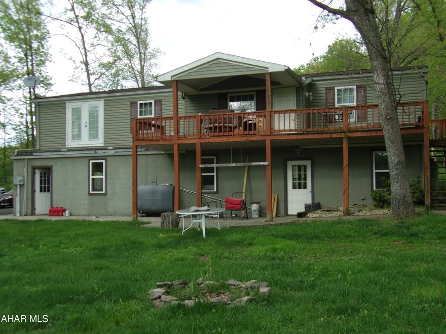 11+ acres!!!  Peaceful, Private setting, but close to schools and most amenities.  Plenty of room for everyone in this 4 bedroom, 3 bath vinyl sided doublewide.  Enjoy morning coffee and evening beverages on the spacious deck, overlooking the property.  It's so relaxing, you'll want to live out there.  The two car garage opens into the ground level walkout finished basement with a stone fireplace and access to the paved patio with firepit.  With full sized windows and 3 exits, this space has the potential to be converted into a separate living space for guests, family, or profit.  Come take a look. This just might be the home for you!