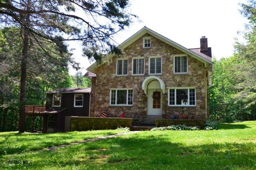 This tranquil setting is located on 5.2 Acres in beautiful Sinking Valley.  As you enter the front door there is a living room with built in bookshelves, and fireplace for entertaining.  Next you walk into the large dining room that overlooks the front yard that includes a stream,and fire pit.  The family room has sliding glass doors, lots of windows for natural light, and access to the wraparound deck.  The kitchen is a central location with access to each room on the main floor.  If there is not enough for you to do in this 4 bedroom 1.5 bathroom one of a kind stone house, the 4 bay garage will keep you busy, but that is not all.  This property also offers a guest house with 3 bedrooms and 1.5 bathrooms of its own.  The possibilities are endless, and you will never want to leave.