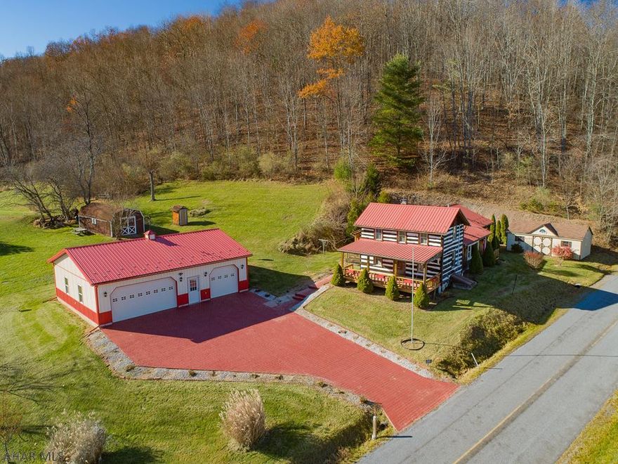 The Great Escape.  Off a quiet country lane only 17 miles from State College perfectly placed on 54.55 serene acres you will find this countryside log home overflowing w/charm.  Inviting covered front porch leads you to the spacious & relaxed interior.  Large family room w/vaulted ceiling, exposed logs & cozy propane fireplace.  Updated kitchen w/solid wood cabinetry as well as built-in window benches, solid surface countertops & a breakfast nook with a cozy coal stove.  1st floor master boasts a private full bath as well as a handy laundry room.  There are 2 large detached metal buildings/garages (30x30 & 14x40) delivering 5 total stalls providing tons of storage & workspace.  Bell Hollow Run flows thru the lower portion` of the acreage divided by the road.  True country living.