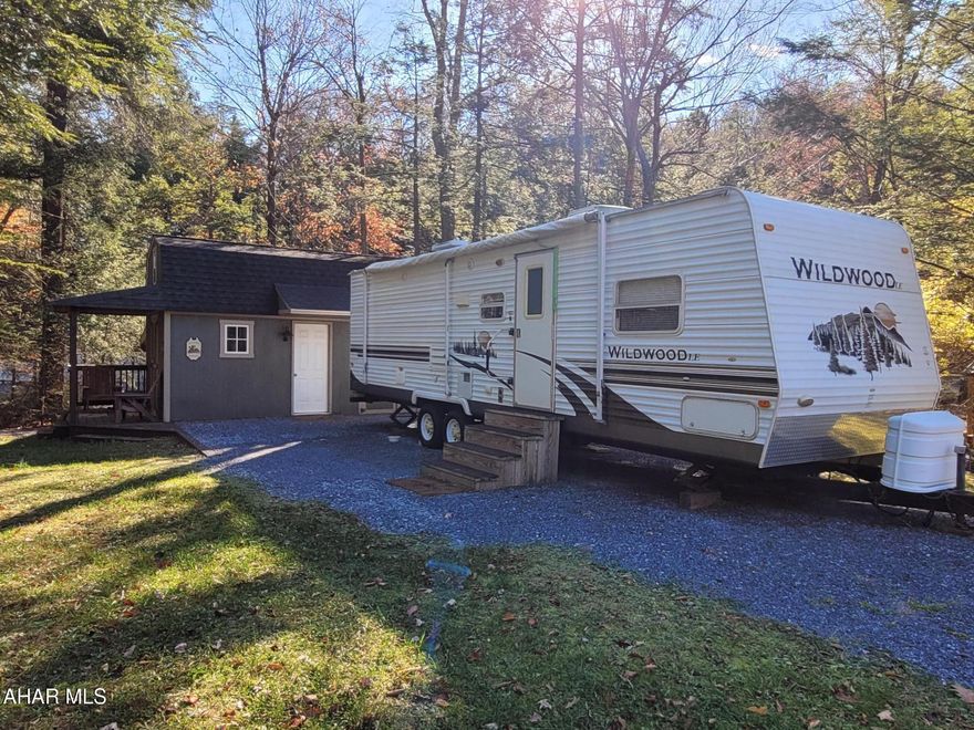 Semi-private campsite with camper and extra sleeping room and bathroom in shed.  Camper  has a slide out that offers extra room inside.  It features two bedrooms along with a futon and a bath.  Inside the shed is a loft bedroom along with kitchen/living space area on the ground floor and a full bathroom.  The outside area has seating around your fire pit area.  Campsite is wooded and is adjacent to a creek.  Enjoy nature and all the amenities of Glendale Yearound as well:  swimming pool, clubhouse, tennis/basketball/volleyball/horseshoes, two playgrounds, dog park, planned activities, catch and release pond and more.  
Pictures do not show the camper with the slide out open.