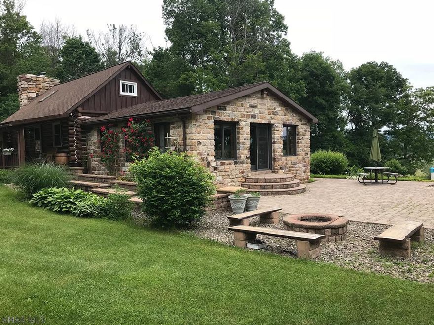 This stunning home will capture your heart!  Enjoy the wildlife, fruit trees, and multiple gardens that surround this lovely stone and log home, lovingly called the Freedom House.  Outdoor entertainment includes 2.5 acres of land to roam, a cozy fire pit, beautiful stone fountain, and the quaint "Raspberry Cottage."  Step inside and feel right at home in large living areas with rustic charm.  The living room boasts a fabulous stone fireplace, featuring a wood-burning insert that makes the whole house feeling warm and inviting.  The great room yields amazing views on every side, and the vaulted ceilings make it the perfect entertainment spot!  The logs of the home were resealed inside and out within the last 3 years.  Just minutes from popular hunting and fishing destinations.