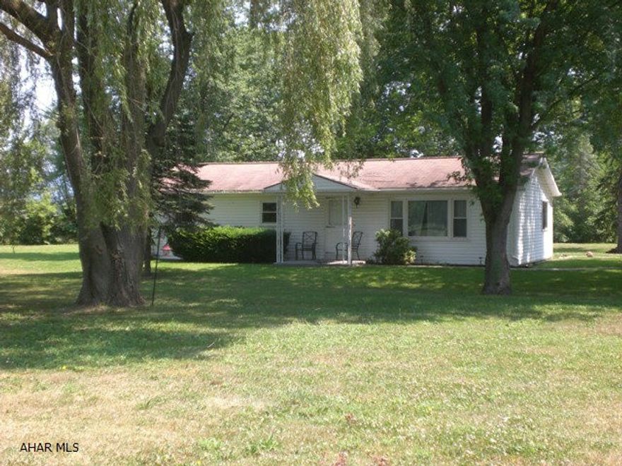Country ranch home resting on 1.66 acres. Nice level lot w/mature trees.Home offers a LR w/picture window, Kit, DR, 3 Beds and 1 Bath. Detached 4-car garage and front and rear covered porches. Newer vinyl siding & windows.