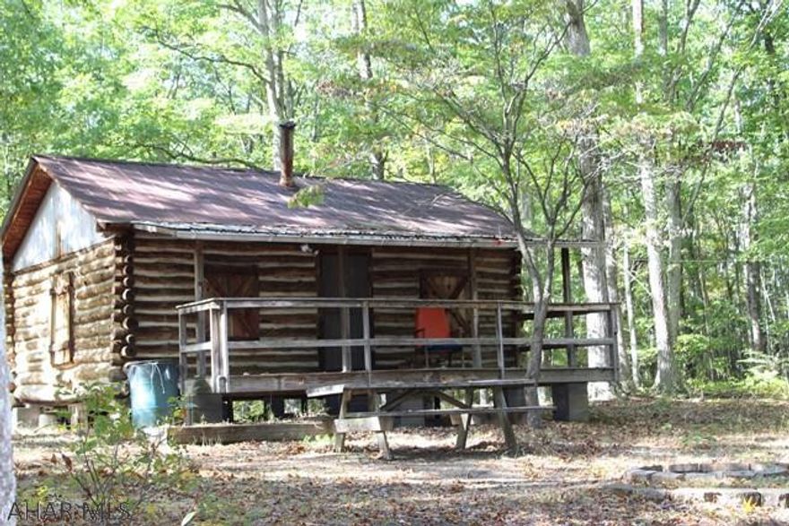 Looking for a peaceful retreat or Hunting Cabin, This is a must see.  15 acres located near state game lands.  A Beautiful Log Cabin sits at the top of property with 2 porches for your enjoyment.  The cabin is an open room with a mini kitchen suite concept with electric.  A firebrick lined fire ring sits off front of the house.  There are no visible neighbors from the cabin with the only noise is the sound of the acorns falling from the trees and the wild animals.  There is an outbuilding with 2 - 8X8 doors with an upstairs storage area that could be used for a barn or a garage that has electric.   A small pond is at the entrance to driveway that could be opened up and cared for with a little TLC.  By the pond is a  clearing about 2-3 acres.  Well and outhouse on property by cabin.