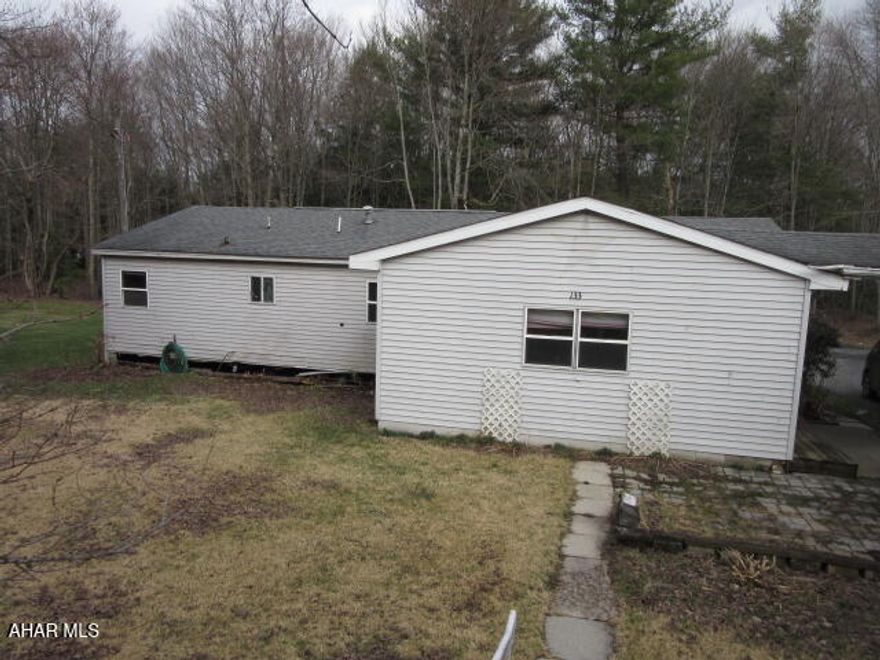 What are you getting with this property? This property is a single wide manufactured trailer with an addition. The living room and two bedrooms are part of the addition and are a step down from the original structure. There are two full baths. One bathroom has a rotted floor and cannot be accessed. The roof had a leak in the living room area and needs repaired or replaced. The oversized garage appears to be a solid structure. The property is accessed from a private dirt road but does border the main road.