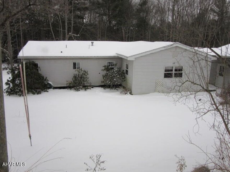 What are you getting with this property? This property is a single wide manufactured trailer with an addition. The living room and two bedrooms are part of the addition and are a step down from the original structure. There are two full baths. One bathroom has a rotted floor and cannot be accessed. The roof had a leak in the living room area and needs repaired or replaced. The oversized garage appears to be a solid structure. The property is accessed from a private dirt road but does border the main road.