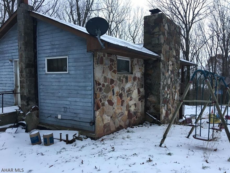 Great opportunity. Almost 5 wooded acres! House is in need of a rehab. 2 fireplaces, walk out basement, large deck. AS-IS sale. Driveway needs work.