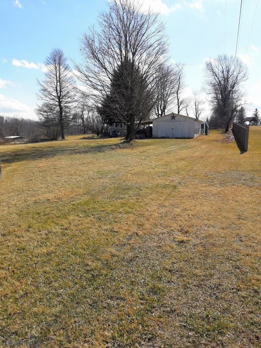This picturesque lot is nestled between farms just outside of Clearville.  This 1.19 acre lot boasts many outbuildings situated on the property including a large shed with a carport as well as a unique canning shed.  Build your dream home or place a new trailer on the lot with electricity, water, and sewage already on the property.  Property being sold AS-IS.