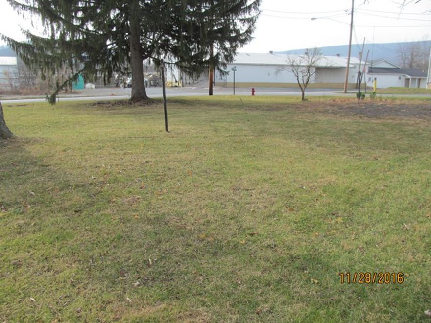 Oh, the possibilities!  Great corner lot.  Build what you want!  Zoning is residential, commercial and manufacturing -  so pretty much the skys the limit as to what you can do with this property.  Start a business.  Build a triplex or an apartment building.   Property can be purchased with the two adjoining properties for one low  price.  The possibilities are endless.