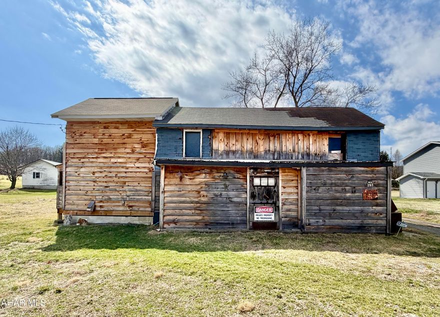 1.25+/- Acres with public water and sewer on site. The property offers a great location for multi-family housing, commercial space, storage units, truck/trailer drop yard, or a single-family home with no zoning. There are multiple structures on site and the large structure has hand hewn logs in a portion of it. The seller will make no repairs.