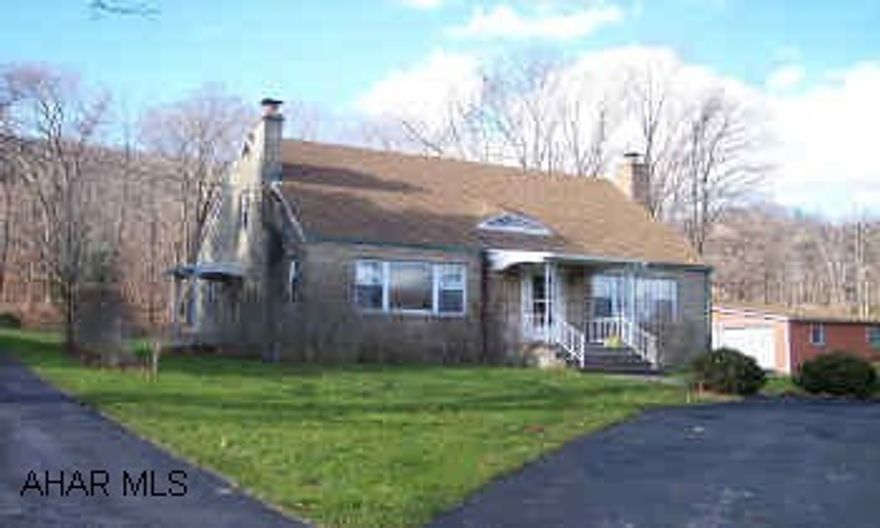 stone encased home with paved drive, wormy oak kitchen cabinets, hardwood floors, and new kitchen floor.  three car detached garage and two story shop with flue ready for wood stove.