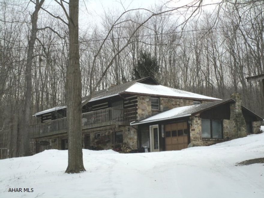 PRICE REDUCTION! Cozy stone/log home on picturesque, wooded setting w/ seasonal stream. Lower/base.level - Fully-exposed ft. wall w/ family rm. w/ pic window, stone FP, barn beams + flagstone foyer w/open stairs; kitchen/dining rm. w/ util. area; rec rm. w/ barn beams & pic window; &, 1 bath. Main/upper level - Living rm. w/ deck & pic window; lg. kitchen/dining rm. w/ cherry cabinets, center island, wall oven, cooktop & pic window; 3 bedrooms; &, 1 bath.  Total house fan.  Wood/coal furnace.  Home has been wired for electric heat on main/upper level(needs installed).  Outbuildings: 2-bay machine shed;3-bay detach. garage/shop w/RV bay. Attach. garage w/fireplace, cave & coal bin accesses.       CLOSE TO SPORTSMEN'S DAM.  ONLY 5 MILES FROM TOWN!