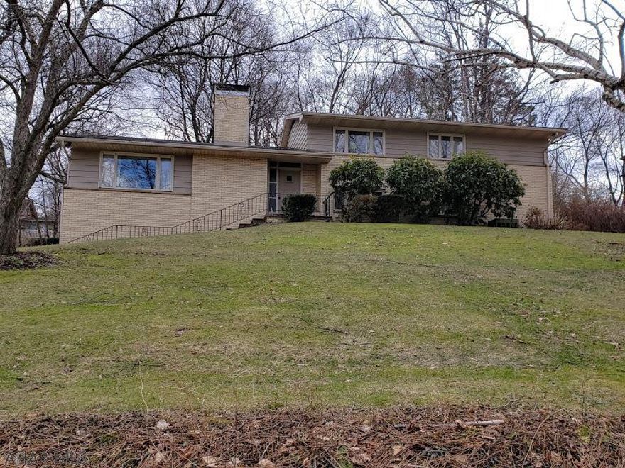 Large home on three-quarter acre, tree line lot in the city. Three large bedrooms, 1.5 baths, 2 car garage, and beautiful views. There are hardwood floors under the carpet in the bedrooms, and lower level family room could be a 4th bedroom. There is a separate laundry room with a laundry chute. The eat-in kitchen includes a wall oven, new refrigerator, and access to the dining room and patio. The yard has macadam basketball court and is completely shaded by mature trees .  Leonard Fiore build this beautiful home which has been meticulously maintained.  Don't miss this very unique and spacious home.