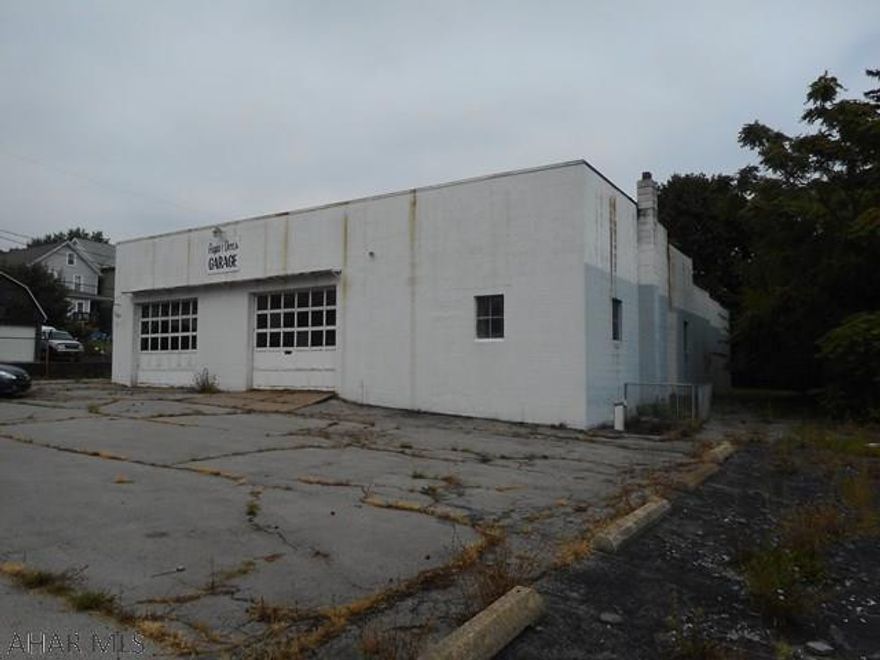 Former car repair garage. Great commanding corner lot with paved fenced in parking. Block building with 3 overhead doors and concrete floor. Office room and small basement area. Location has experienced many upgrades over the past few years making this site a great opportunity!  Holtz and Associates Real Estate, LLC - 814-946-4211.