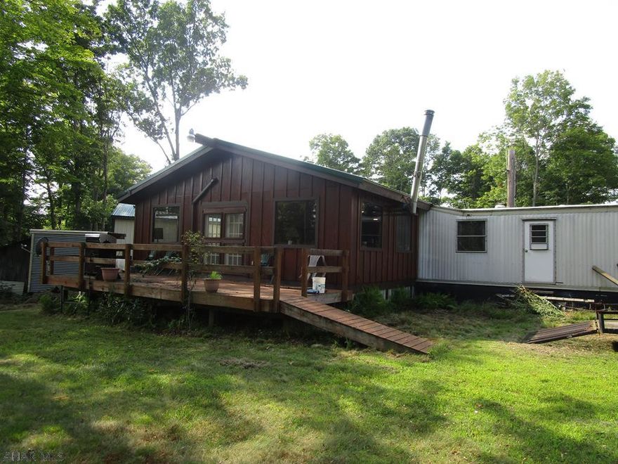 Hunting camp/summer home on 10 acres. Mobile home camp with stick built addition. Rear deck and enclosed front porch.Heat pump and woodburner.  Newer pole garage thats great storage. Woodshed and picnic pavillion. 100yd shooting range. Great hunting area.