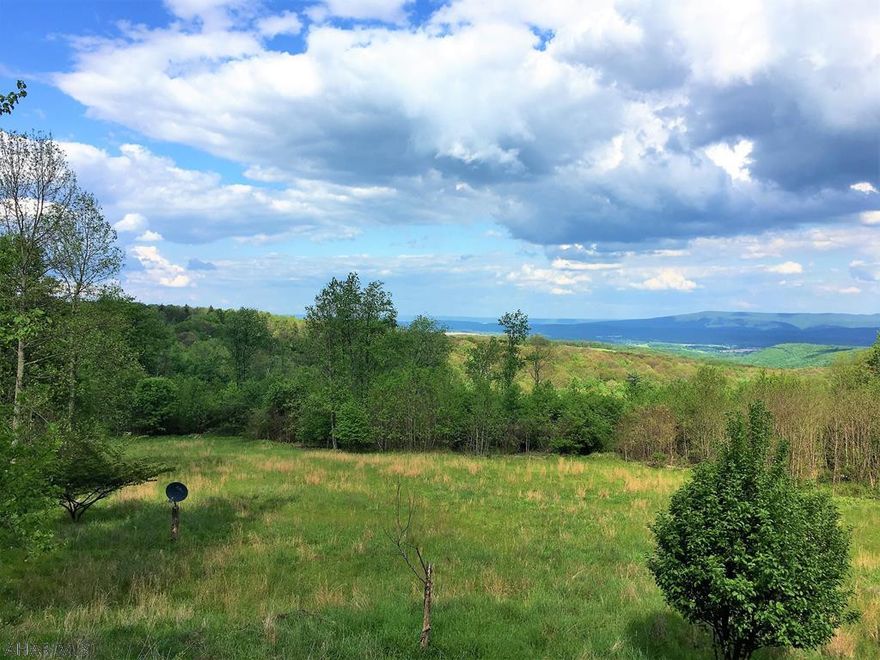 Buy a part of Bedford County history with this hard to find large acreage parcel that was home to the S.S. Grand View Point Hotel, also known as the Ship Hotel or the Ship of the Alleghenies. Enjoy fantastic views of the Allegheny Mountains and Shawnee Lake from the comfort of your living room or the paver patio. This rolling to steep landscape is home to deer, turkey, bear, small game animals and features a stream.  The secluded 1,960 square foot double-wide home sits on a concrete block crawl space.  The kitchen features oak cabinets and flooring. Enjoy the wood fireplace in the family room during the winter months.  All of the bedrooms have walk-in closets.  There is plenty of car parking with a detached two-car garage with a concrete floor and a two-car carport.