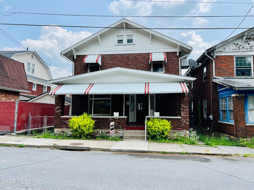 This  brick home exudes timeless elegance and offers a serene retreat with its classic brick exterior and charming features.  Stepping inside, you are immediately enveloped in the warmth and character that the interior exudes. The original  hardwood floors throughout the home lend a touch of elegance, while the high ceilings create an open and airy atmosphere.   The  living room and dining room, feature large windows that allow an abundance of natural light to fill the rooms.  The kitchen has been recently updated with white cabinets and new countertops.  New LVT has been installed in the kitchen and bathroom.  All woodwork is original.
