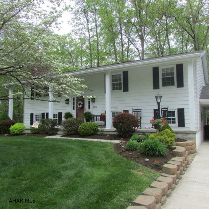 Elegant and impeccable home in a quiet neighborhood. Extremely well maintained inside and out. Lots of new - kitchen and baths! A gas fireplace in the Living Room. Hardwood and ceramic tile floors. The Dining Room opens to a 12x20 screened-in porch that overlooks a lovely fenced-in yard w/the sound of the stone waterfall.  44' of front porch.  A carport to the right with parking for two.  The lower level entrance has country red ceramic tile that leads to a large full bath with a Jacuzzi tub. Two full baths upstairs.  The kitchen has had a makeover! - there's a new designer section added with additional storage and decorative lighting. The downstairs offers a large workshop area that's 14x21 plus another room with built-in storage racks. A newer heat pump/AC system. Low utilities!