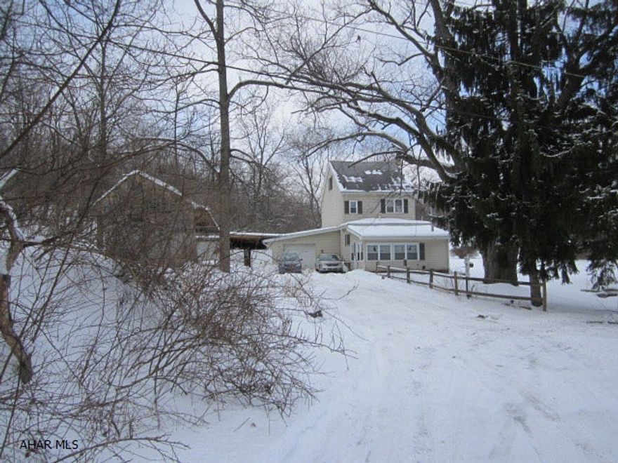 WANT PRIVACY IN THE MIDDLE OF TOWN? Located in Juniata a one of a kind property with 6+ acres. Sit at your kitchen table and look over the large grassy field nestled between wooded hillsides. The vinyl sided home has new windows and new furnace w/CA. There are multiple garages and heated work shop. Priced to Sell and super low taxes.