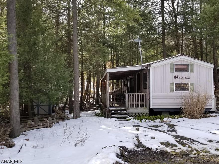 1989 Mallard park model camper on 1 lot inside Glendale Yearound. Camper is 2 bedroom and 1 bathroom and has a covered deck attached. Property has 2 sheds and a stream running right beside it. Fully furnished and ready to use in winter or summer. Glendale Yearound is a gated community located minutes from Glendale Lake, Prince Gallitzin State Park, and Rock Run ATV Park. Community pool, tennis, basketball, and more.