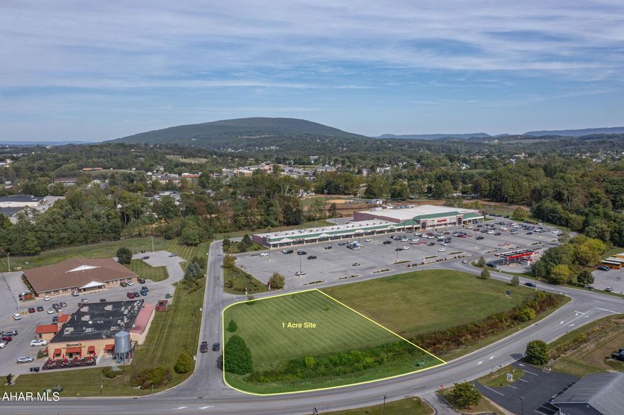 A prime 1-acre commercial parcel positioned at the entrance to Martins Grocery in the well-established Holliday Towne Center. This site offers excellent visibility, immediate access, and strong consumer traffic generated by surrounding national and regional tenants. Located just off Patch Way Road, the parcel benefits from direct access to Route 22 and close proximity to I-99 and Plank Road, connecting Duncansville, Altoona, and Hollidaysburg.
The lot is flat, cleared, and development-ready, with all public utilities available—ideal for a restaurant, bank, office, or retail user seeking a proven location in a high-traffic trade area.

Key Highlights:
±1.00-acre commercial parcel
Outparcel to Martins grocery store within Holliday Towne Center
Excellent access to Route 22, I-99, and Plank Road
Public water, sewer, gas, and electric available on site
Level topography for efficient site work and construction
Shared access drives and infrastructure within established retail center
Surrounded by strong co-tenancy

Why This Site Stands Out:
High visibility with frontage along a major retail access road
Established infrastructure reduces development lead time
Anchor-driven traffic from Martins Grocery and neighboring businesses
Proximity to I-99 and Route 22 supports regional access and logistics
Ready-to-build parcel within a cohesive, high-quality development