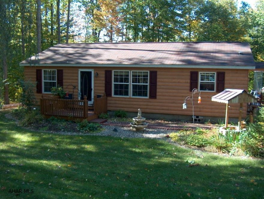 Beautiful 1997 log sided doublewide in excellent condition  2x6 walls, insulated windows. Totally redone inside & out! carport 24 x 26 x10 shed 12 x16 w/ 10 x 10 addition Tar & chip driveway, wrap around deck. A must see!