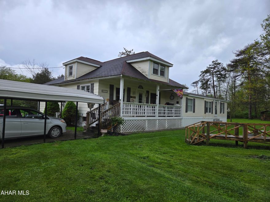 Check out this unique property located on 1.35 acres in the Bellwood-Antis School District. This 4 Bedroom, 3 full bath home features 2 kitchens, and 2 living rooms. This home sits on a corner lot with woods on 3 sides, 2 carports, a closed pavilion, pond, public water and private septic system.
Close to the 'Little Juniata River' and woods.
Enjoy the view from the covered porch.
Add your own touches to make this your dream home! This home is both a 20th century Bungalow and a 'Manufactured Home'