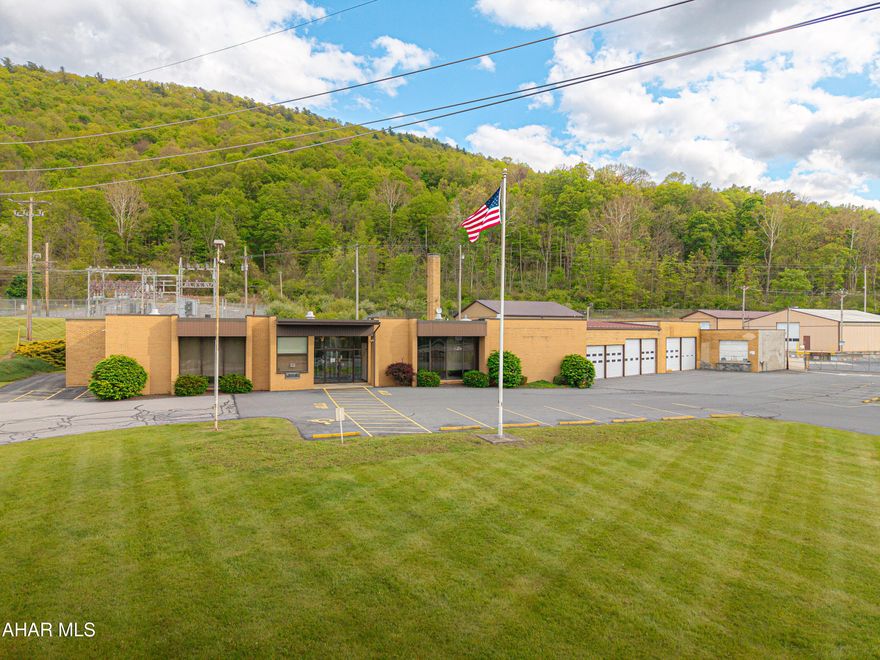 Rare opportunity to own a highly versatile 10.28-acre commercial property just outside of the Bedford Borough. This well-maintained property offers a one-story masonry building designed for a variety of business operations, featuring a welcoming reception area, private offices, restrooms, employee break room, kitchen area, board room, and multiple training rooms. The property is exceptionally equipped for commercial and industrial use with an attached garage offering both interior and exterior loading docks, along with multiple large detached garages and ample space for storage, fleet parking, equipment, or expansion. Security fencing surrounds the site, providing added privacy and protection. Heating and cooling systems include geothermal heat pumps, mini-splits, traditional heat pumps, oil heat, and central air conditioning for efficient year-round comfort. Public sewer, well water, and a spring-fed pond further enhance the property's utility and appeal. Ideally suited for professional office operations, automotive services, trucking, warehousing, manufacturing, contractor headquarters, distribution, or storage use. Conveniently located with easy access to major roadways and downtown Bedford, this is a unique opportunity to acquire a flexible commercial property with exceptional potential.
