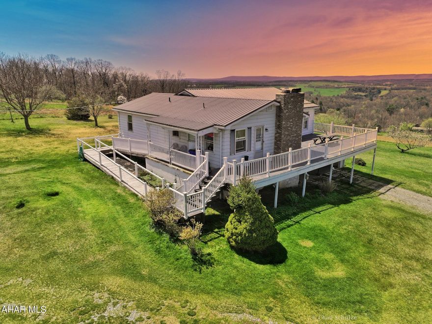 Well maintained raised ranch on a pristine lot just shy of 5 acres! Stunning hilltop location with scenic views all the way to Maryland! See aerial photos for just a small preview of the beauty of 3116 West Mattie Road. Enjoy these sights from inside in the spacious panoramic sun room. Walls of windows to enjoy your country oasis and all of the natural light. Property features kitchen, dining room, living room, sun room/ family room, two bedrooms on main floor, one with walk in closet and en suite bath and one full bath in hallway on main floor. Bedroom, full bath and family room/rec room in finished basement with walk-out door and full size window. Attached two car garage. Sizeable wrap around deck that can be accessed from sun room, kitchen and dining room is just perfect for entertaining. Bonus outbuilding that has it's own kitchen and bathroom would make a perfect small apartment or guest area with some remodeling. Basement would also make a nice in-law suite or guest area. So much opportunity at this home, don't miss your chance to check it out! Set up your showing today.