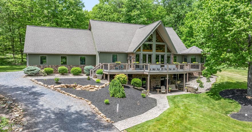 Welcome to your serene sanctuary, where peace & tranquility prosper. This exquisite, fully custom A-Frame home, built in 2007, sitting on approximately 8 acres is nestled within the Forest Hills School District. The stunning architecture captivates from the moment you arrive, both inside & out. Step into the main floor & be welcomed by a magnificent living room adorned w/ soaring cathedral ceilings & a wall of windows that invite natural light to flood the space. The adjacent kitchen is a chef's dream, featuring a generous island, & flows seamlessly into an octagonal dining room that offers breathtaking 360-degree views. Throughout the home take note of all of the beautiful oak woodworking. On this level, you'll also find a luxurious master suite complete w/ an expansive custom bathroom featuring a glass block shower to die for. Additionally, there is a guest bedroom, a full bathroom, a convenient mudroom, & a dedicated laundry space. Venture upstairs to discover even more incredible vistas of the pond out front, along w/ two spacious bedrooms & another full bathroom, perfect for family or guests. The finished basement is a true gem, encapsulating the home's unique character & charm. It boasts a large living area, a full kitchen, a roomy bedroom, & a beautifully designed custom bathroom, along w/ laundry & a cozy pellet stove. Currently, the basement operates as a highly successful Airbnb, ranking in the top 1% of listings offering additional income opportunities. The exterior of the property is equally breathtaking, featuring a substantial pond complete w/ a fountain, a custom waterfall, an oversized two-car attached garage, a generous covered rear porch, & a vast front deck that offers additional seating beneath. Set on 8 acres of pristine land, the property is teeming with wildlife & offers a myriad of possibilities. Everything you've ever dreamed of awaits you here! Call today!