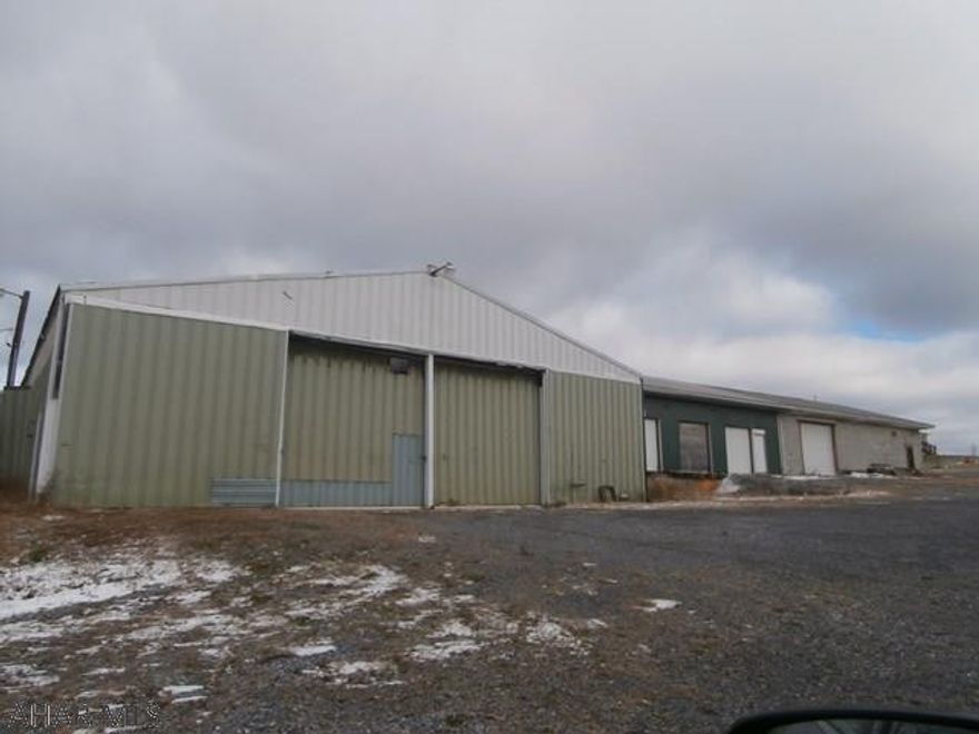 Large garage on 1.8 acres+/-. Level lot with parking and turn around areas. Corner lot. Garage has overhead doors and concrete floor. Three loading docks. Two furnaces. 1/2 Bath needs some pipe work. Great truck garage or shop.