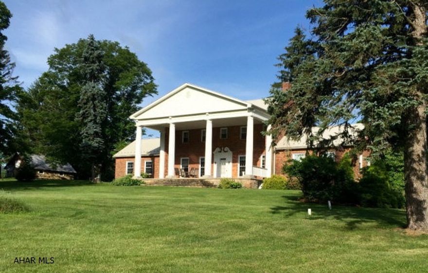Located within a 10 minute drive of Omni Bedford Springs sits this stately 15 acre farmette in historic Bedford County. Stunning views of State Game Lands and Alleghany Mountain side surrounds the home. A soaring 2-story front porch with stately pillars overlooks the scenic stocked pond. Vinyl fencing, newly renovated barn and outbuildings add great appeal for a horse or a hobby farm. There is an abundance of natural light that flows throughout the home with the many large windows. Many renovations ensure that this home will not disappoint inside and out. Main floor master suite, two fireplaces, central air, large dining room surrounded by windows, huge front and back outdoor dining areas plus a historic circa 1800s pioneer log school house make this a very special property.