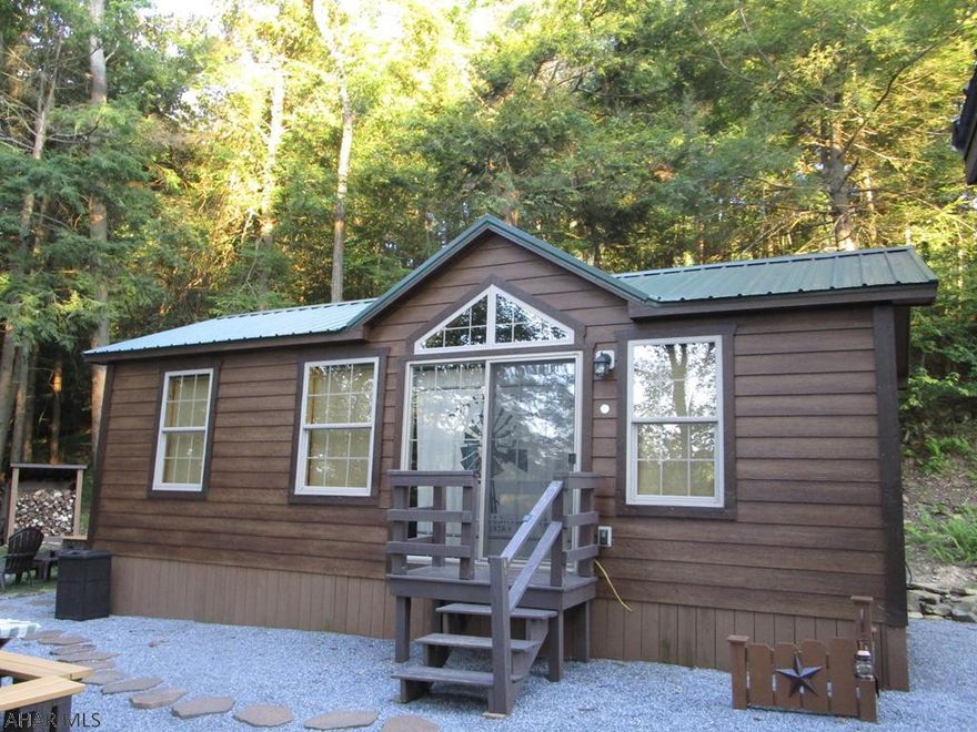 Exquisite small cabin with all you need in a cute package.  Two bedrooms sleep six in beds.  Full bath with tub / shower.  Kitchen / living room that includes a bar and upgraded appliances.  Everything is like new and well maintained inside and out.  Very private site at the end of a short lane.  Two adjacent lots are also for sale separately if you want your own private domain.  All of the touches to make this your favorite place to be.  Storage shed for your toys and tools.  Great fire pit and clean up area.  Situated in the woods and, I repeat, private.  Cabin is a park model with a title.