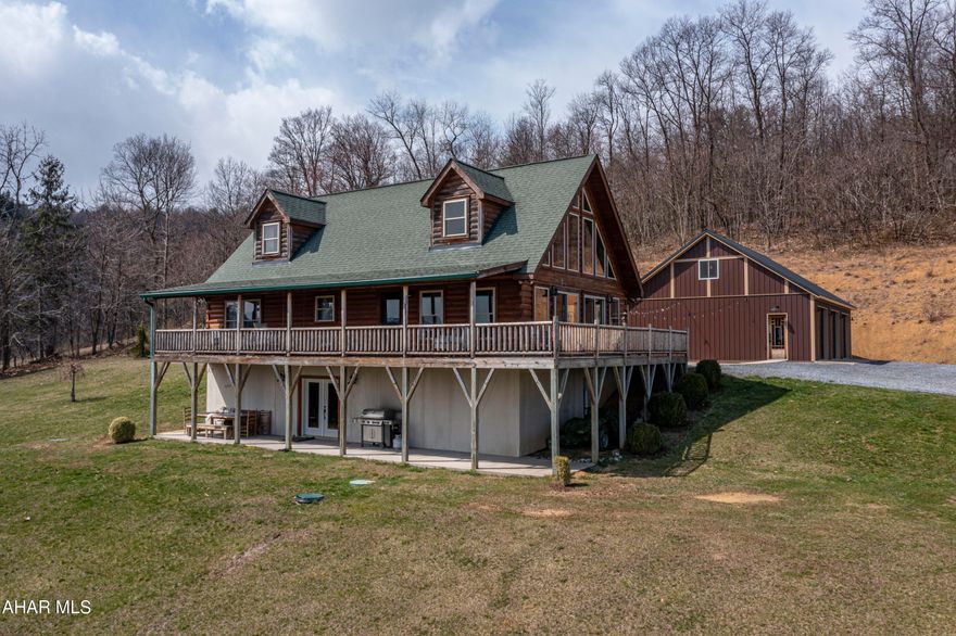 This commanding log home sits perched on a gently rising hill overlooking more than 4.5 acres of open fields and open skies. Partially wooded, and situated comfortably away from the road, this home imbues the pastoral charm of country living without ceding any of the conveniences of modern life.

The focal point of the home, sure to draw immediate attention from visitors, is the grand 20-foot wall of windows which capture the sunlight and illuminate the home's open concept floor plan underneath imposing cathedral ceilings. A lovely kitchen, studded with modern fixtures and appliances, includes a demonstrable island. Home systems are both energy and cost efficient, hosting a geothermal heating and cooling system.

The master bedroom is situated on the main floor, and its adjoining master bathroom includes a garden jacuzzi tub and double sink vanity. A second bedroom, also located on the main floor, flaunts a generous walk-in closet and laundry facilities included in its full bathroom. The loft also includes its own full bathroom, and its space is easily convertible into another bedroom, a home office, or entertainment room.

The lower level possesses a full suite, complete with living room, kitchenette, bedroom, additional closets, and lavishly sized full bathroom; ideal for family and guests on extended visits. French doors lead to a covered patio, perfect for outdoor dining, grilling, and any summertime event. The 3-bay garage measures 30'x40', with plenty of room for multiple vehicles, equipment, and other storage.

Finally, an eastward facing deck gives you the opportunity to catch the rising sun every morning as you peer over your  piece of paradise.

Centrally located in the heart of this region, and with convenient access to I99, I70, I68, and the Pennsylvania Turnpike, you are only a two hour drive from each of the major metropolitan areas like Pittsburgh, Washington DC, and Baltimore. And for outdoor recreation closer to home, it's only a few minutes drive from the beautiful Omni Bedford Springs Resort, Shawnee State Park, Blue Knob Ski Resort, and Rocky Gap State Park.

We welcome you home to 665 Lafayette Road, New Enterprise, Pennsylvania.