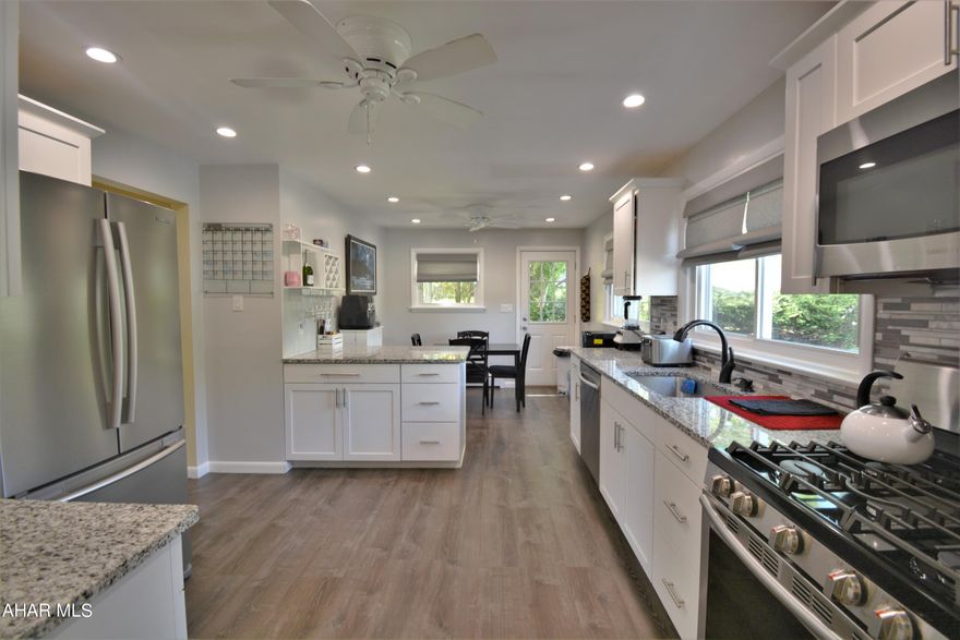 RADIANT RAISED RANCH!  This home is one you WANT to see!!  It is so light, bright & airy and has a wonderful flow to it.  Upon entry you can go into the large living room or head straight into the beautiful kitchen--fully updated with granite counters, tile blacksplash, SS appls, a large peninsula, vinyl plank floors & an eat-in area.  There are 3 BRS, with one currently set up as an office with built-in desks for working from home & another with a custom open closet system to help you stay neat & tidy. The full bath is updated, right next to the Master BR.  The basement offers a garage & a ton more livable space, with a half bath, utility/laundry area & big magnificent family room that leads out to the back patio.  The outdoor area is perfect to relax on this summer with a covered space that has a TV (that stays!) & another area uncovered if it's sun that you want.  Also back here is a fenced in yard area offering you just the right amount of green space to not be overwhelming.  Call today to see this one first hand!