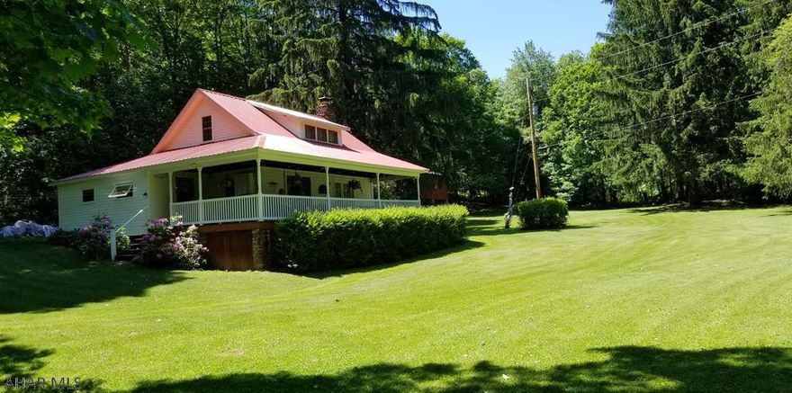 Country Cottage on 26.74 acres , has a survey. It makes a great vacation home ,has a little bit of everything you are looking for... Stream, pond, garden area, fire pit,  flat space yard, woods and mountain ground. Cabin is charming with beautiful red hardwood walls in living room , also very unique lights in living room. One full bathroom. Heat source is currently the wood fireplace and space heaters. Go upstairs and see all the beds set up to sleep at least 10 easily. Enjoy the wraparound covered porch with unique swing to enjoy the gentle flow of the stream and watch nature. Storage shed is full of many unique and usable items . SIgn at end of Drive.